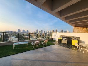 a balcony with a view of a city skyline at Luxurious penthouse for couples in Kiryat Mozkin in Qiryat Motzkin