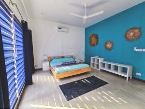 a bedroom with a bed and a blue wall at Villa Nyota Zanzibar in Kidenga