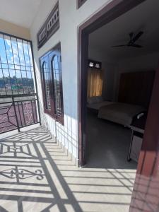 Zimmer mit einer Tür, die zu einem Zimmer mit einem Bett führt in der Unterkunft BKR homestay 2bhk in Itānagar