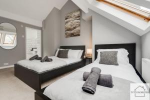 a bedroom with two beds and a mirror at Elegant Home from Home in Manchester