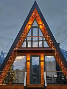 a house with a triangle roof with lights on it at B&B Cottage in Mestia in Mestia