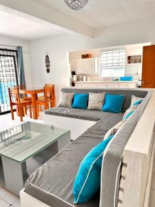 ein Wohnzimmer mit 2 Sofas und einem Tisch in der Unterkunft South Coast Private on the Beach in Christchurch
