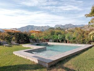 a swimming pool in a yard with mountains in the background at Villa Aguacate in Nerja