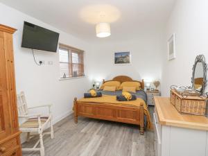 a bedroom with a bed and a flat screen tv at The Pepper Pot Retreat in Ventnor