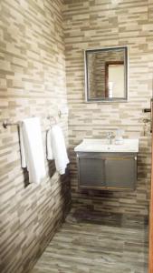 盧薩卡的住宿－KKI Serviced Apartments，一间带水槽和镜子的浴室