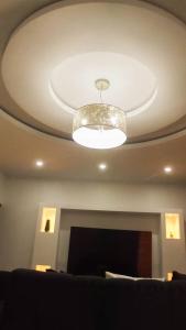 a living room with a ceiling with a light at KKI Serviced Apartments in Lusaka