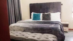 1 dormitorio con 1 cama grande y 2 almohadas en KKI Serviced Apartments, en Lusaka