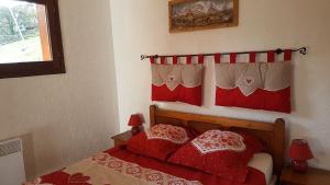 1 dormitorio con 1 cama roja y 2 almohadas rojas en Etoile des Alpes, en Saint-Gervais-les-Bains