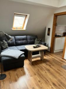 a living room with a couch and a table at Ferienwohnung Brockenblick in Wernigerode