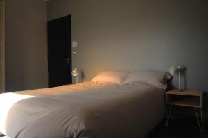a bedroom with a large white bed and a table at Villa contemporaine, jardin méditerranéen et piscine privée in Saint-Jean-Pla-de-Corts