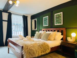 um quarto com uma cama grande e uma parede verde em Friar Loft em Worcester