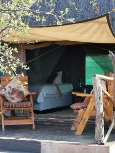 Tienda con cama, mesa y sillas en Kruger Buffalo Hill Lodge, en Phalaborwa