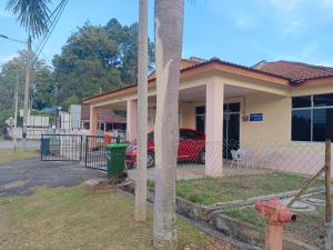 a house with a red car parked in front of it at KASIH JERAI HOMESTAY, Gurun, Guar Chempedak in Guar Chempedak