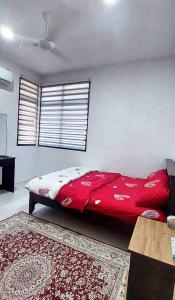 a bedroom with a red bed and a rug at KASIH JERAI HOMESTAY, Gurun, Guar Chempedak in Guar Chempedak