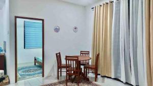 a dining room with a table and chairs and a mirror at KASIH JERAI HOMESTAY, Gurun, Guar Chempedak in Guar Chempedak +7 photos
