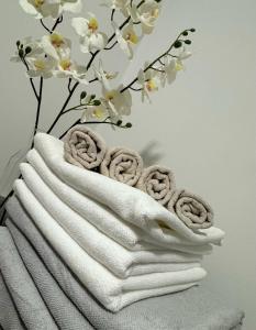 a stack of towels with a vase with white flowers at Elena Apartments in Ljubljana
