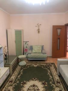 ein Wohnzimmer mit einem Sofa und einem Spiegel in der Unterkunft Квартира in Almaty