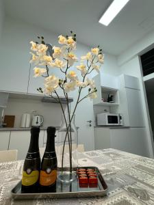 two bottles of beer on a tray with a flower at Elena Apartments in Ljubljana