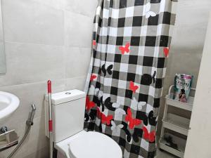 a bathroom with a toilet and a black and white shower curtain at Private condo w/ balcony near Batasan, Ateneo, UP, Diliman, The Residences at Commonwealth in Manila