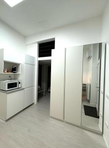 a white kitchen with white cabinets and a microwave at Elena Apartments in Ljubljana
