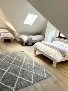 a attic bedroom with two beds and a rug at Apartmány Louka in Vaclavov u Bruntalu