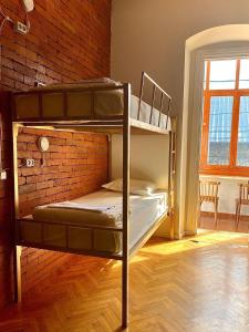トビリシにあるFriends Hostelのレンガの壁の客室で、二段ベッド2組が備わります。