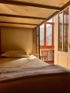 1 cama en una habitación junto a una ventana en Friends Hostel en Tiflis