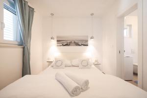 a bedroom with a white bed with towels on it at Apartment Floresita in Zadar