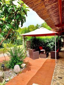 a patio with an umbrella and a table and chairs at LA DEPENDANCE in Su Forti