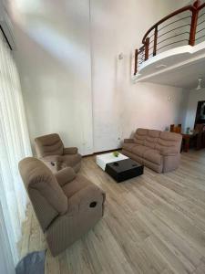 a living room with two chairs and a couch at Elite Escapes in Malabe