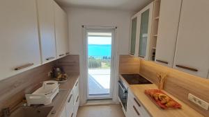 a kitchen with white cabinets and a large window at Villa Stjepan in Zavala