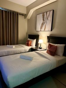 馬尼拉的住宿－G Square Residences，两张位于酒店客房的床,配有两张sidx sidx单人床