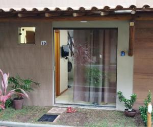 Aconchego da Jandaia في ايمباسّاي: منزل فيه باب زجاجي منزلق فيه نباتات
