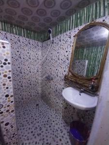 a bathroom with a sink and a mirror at Orange Beach hostel in Cape Coast