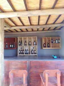 dos sillas sentadas en un bar con botellas de alcohol en Kruger Buffalo Hill Lodge, en Phalaborwa