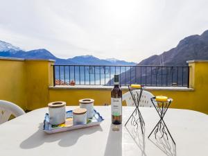 a bottle of wine and two cups on a table at Rododendro House - Lake View and Pool Relax in Morbio