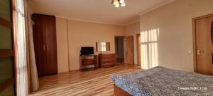 1 dormitorio con 1 cama y TV en ЖК БОТАНИКА en Aktau