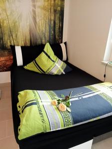 a bed with yellow and blue sheets and flowers on it at Ferienzimmer Waldzauber in Borkwalde