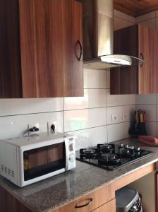 a kitchen with a white microwave and a stove at Meublé de tourisme Makaze in Saint-Louis