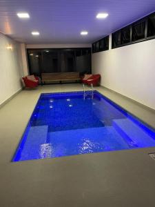 a swimming pool with blue water in a building at Pousada Flor de Anis in Alto Paraíso de Goiás