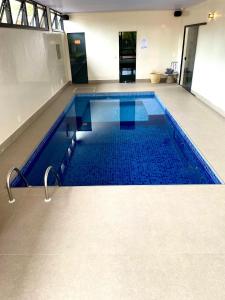 una gran piscina con azulejos azules en el suelo en Pousada Flor de Anis en Alto Paraíso de Goiás