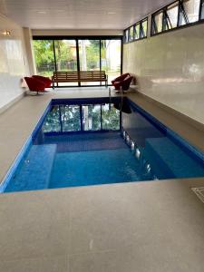 a swimming pool with blue water in a building at Pousada Flor de Anis in Alto Paraíso de Goiás