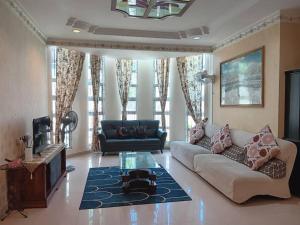 a living room with a couch and a tv at Homestay Banglo Alor Setar in Alor Setar