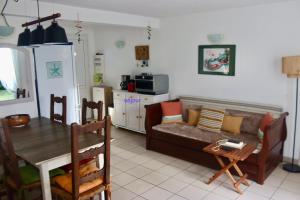 a living room with a couch and a table at Près des claires in Le Château-dʼOléron