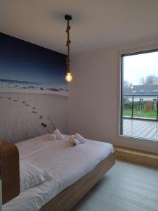 Un dormitorio con una cama con dos ositos de peluche. en TY COAT - Maison neuve avec vue mer, piscine et bain nordique, en Saint-Pabu