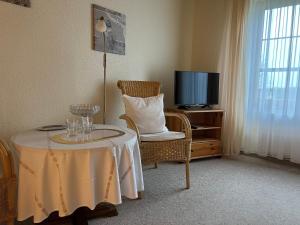 Zimmer mit einem Tisch, einem Stuhl und einem TV in der Unterkunft Gästehaus-Erbst in Loxstedt