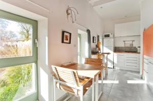 a kitchen with a table and chairs and a window at La Ligne in Angles-sur-lʼAnglin