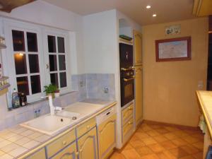 uma cozinha com um lavatório e um fogão forno superior em Augettes Longère normande em Saint-Hymer