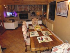 uma sala de jantar com uma mesa e uma lareira em Augettes Longère normande em Saint-Hymer