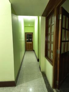 een hal met groene en witte muren en een deur bij Arcadian Home Stay in Shillong
